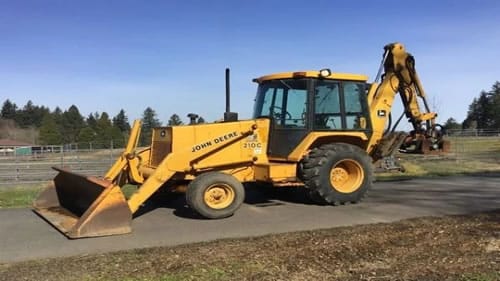 Cat Repair Manual (PDF) John Deere backhoe loader excavator with front loader bucket and rear digging arm outdoors